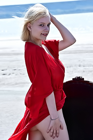 Raquel Drops A Red Robe On The Windy Sand