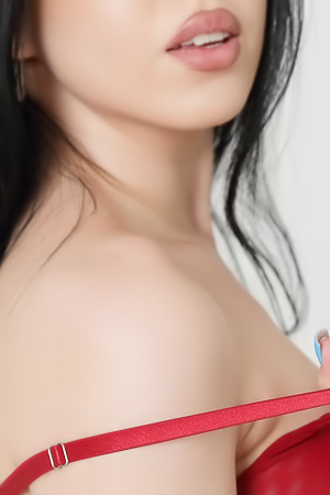 Kris Sis earrings sway slightly as she slowly removes her long dress, revealing bare skin
